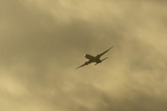 Commercial passenger airliner jet aircraft in flight at sunset at London Stansted airport, Essex,