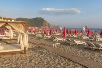 Alanya, Turkey. July 9th 2024 Sunbeds and pink sunshades on Cleopatra Beach in the Turkish holiday