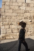 Ankara, Turkey. November 17th 2020 Simit seller walking past old city walls with Roman numerals
