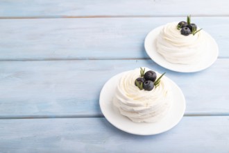 Pavlova Meringue dessert with crisp meringue and blueberry on blue wooden background, copy space,