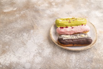 Glazed Eclairs on brown concrete on brown concrete, side view, copy space