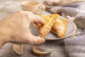 Triangles Pie, Puff Pastry, Samsa with cherry jam on brown concrete background and linen textile