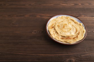 Stack of Plain Fried pancakes on brown wooden background. side view, copy space