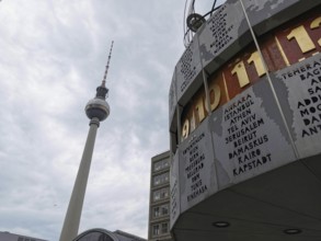 View of the Berlin TV Tower and the World Clock on Alexanderplatz under a cloudy sky, Berlin