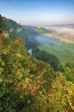 View of the ruins of Saaleck and Rudelsburg castles and the river Saale in autumn morning fog in