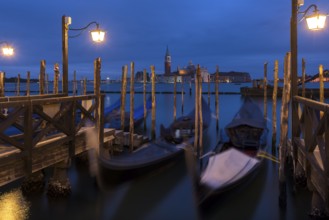 Nighttime atmosphere with moving gondolas, San Georgio Maggiore in the back, Guidecca Island on the