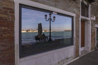 Venice is reflected in a shop window on the island of Guidecca, Venice, Veneto, Italy