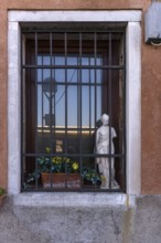 Sculpture behind a latticed window, Venice, Veneto, Italy