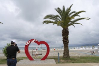 Batumi, Georgia. July 21st 2025. A father takes a photo of his daughter with the heart shaped