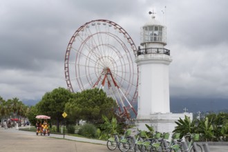 Batumi, Georgia. July 21st 2025. A light house and Ferris wheel with parked bicycles for hire on