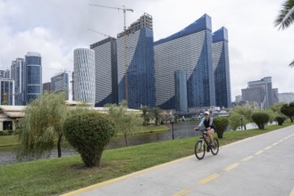 Batumi, Georgia. July 21st 2025. A woman cycles along a dedicated cycle path beside the Georgian
