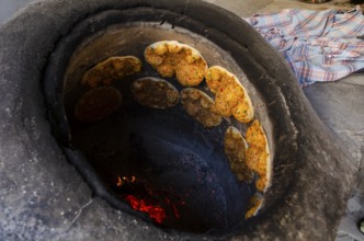 Delicious Turkish Biberli Ekmek Flat bread with red pepper paste cooking in a traditional oven in