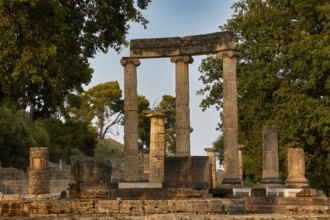 Philippeion, Sublime ancient columns in an archaeological site with trees in the background,