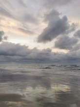 Cloudy sky over a calm sea at sunset with reflections in water, Fresh Spit, Baltic Sea, Poland