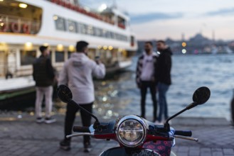 A scooter during evening time beside the Bosporus Straight at the Karakoy Ferry port near the