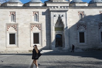 Istanbul, Turkey. January 3rd 2025. A young blond woman walks past a historical mosque near the