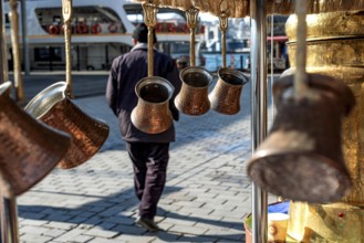 Traditional Turkish copper coffee pots hanging from a street stall beside the Karakoy ferry port,