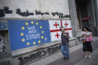 Tbilisi, Georgia. August 26th 2025. Georgian people walk past the flags of Georgia and the European