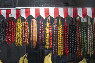 A colorful shop display of Churchkhela, a popular sweet snack made of nuts threaded on string and