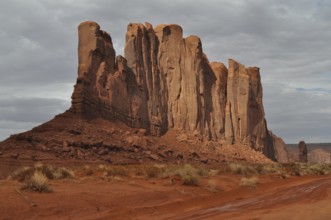 Majestic rocks in bright red rise in a barren desert landscape after a severe thunderstorm,