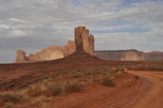 Distinctive tall rock rises in a barren, red desert landscape after a severe thunderstorm, Monument