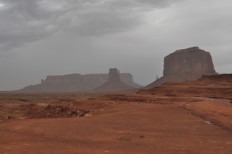 Impressive mesas under a cloudy sky in a vast desert landscape after a severe thunderstorm,