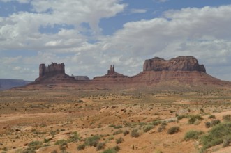 Impressive rock formations rise in a sunny desert landscape, Monument Valley, Navajo Tribal Park,