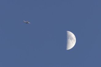 Airbus commercial passenger airliner jet aircraft of British airways in flight with the moon in the