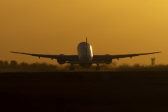 Boeing 777 A7-BFL commercial jet aircraft of Qatar cargo taking off in flight silhouette at sunset