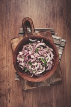 Chopped red onion, with sumac and herbs, in a bowl, pickled Spanish onion, close-up, top view