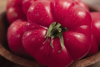Pink tomatoes, in a rustic wooden bowl, close-up, no people