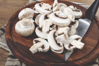 Fresh mushrooms, chopped, in a wooden bowl, whole, top view, no people