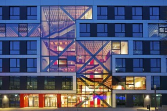 Bochum University seminar building in the evening with an eye-catching staircase with a signal red