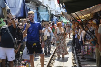 Mae Klong, Thailand. March 15th 2025. Tourists take photographs on the train lines as the 14.30