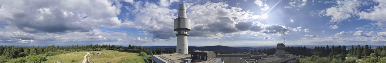 Panoramic view of the Schneeberg with the Backöfele, a high tower under a sunny sky full of clouds,