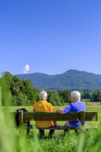 Elderly couple, seniors sitting on a rest bench, Bad Heilbrunn, Upper Bavaria, Bavaria, Germany