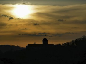 Silhouette of Rosenberg Fortress in Kronach in front of dramatic sunset sky, Frankenwald nature