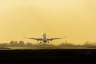 Airbus commercial passenger airliner jet aircraft taking off in flight at sunset at London Stansted