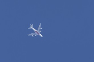 Airbus A380 commercial passenger airliner jet aircraft of Emirates airlines flying in a blue sky,