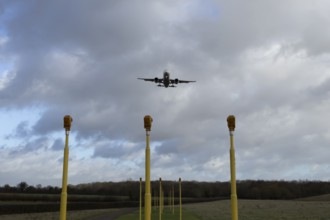 Airbus commercial passenger airliner jet aircraft in flight on approach to land over runway lights