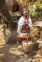 Zulu woman dressed in traditional attire, performing at outdoor cultural event likely in