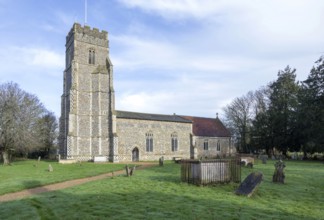 Village parish church of Saints Peter and Paul and its rural churchyard with gravestones,