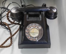 Vintage black analogue dial landline telephone on display at auction, UK