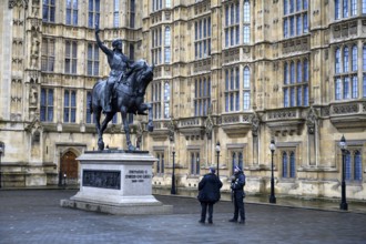 London, UK. January 31st 2025. Two British policemen admire the statue of Richard I on horseback,