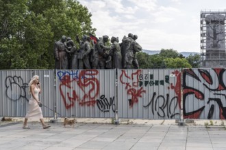 Sofia, Bulgaria. June 21st 2025. A woman walks her dog past the partially dismantled and boarded up