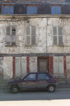 A popular old French car parked outside a typical rural French house in a countryside village in