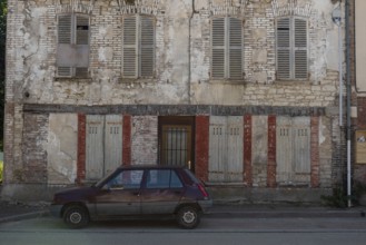 A popular old French car parked outside a typical rural French house in a countryside village in
