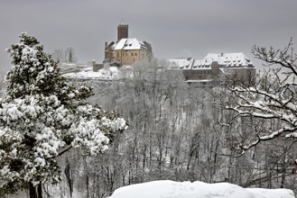 Medieval castle above a snowy forest with cloudy skies, The Wartburg near Eisenach in Thuringia