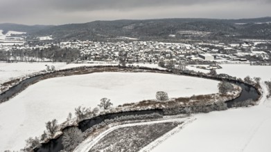 Snowy river landscape with villages and hills under a grey sky, Herleshausen in North Hesse