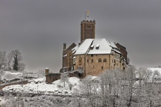 Castle in snow under cloudy sky, no vegetation visible in the foreground, The Wartburg near
